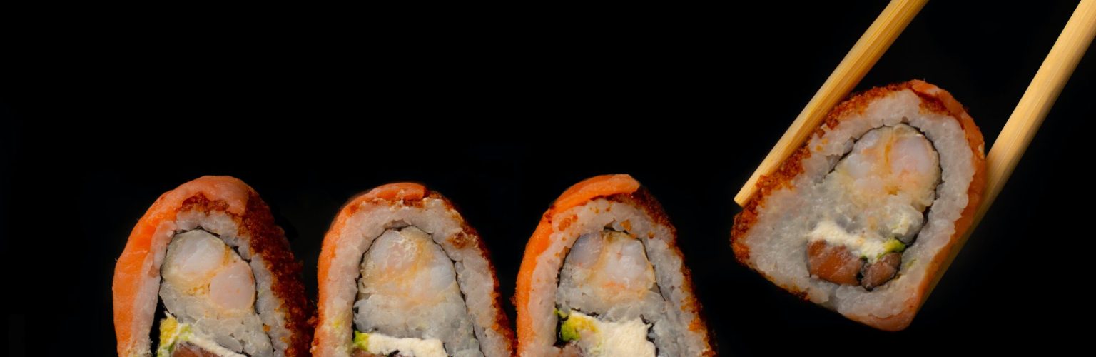 Four sushi rolls with chop stick